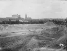 Vy över grustag med Uppsala slott, Akademiska sjukhuset och Uppsala domkyrka i bakgrunden, sannolikt 1909