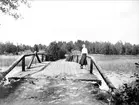 Kvinna på bro, vid Södersjön, Almunge socken, Uppland juni 1933