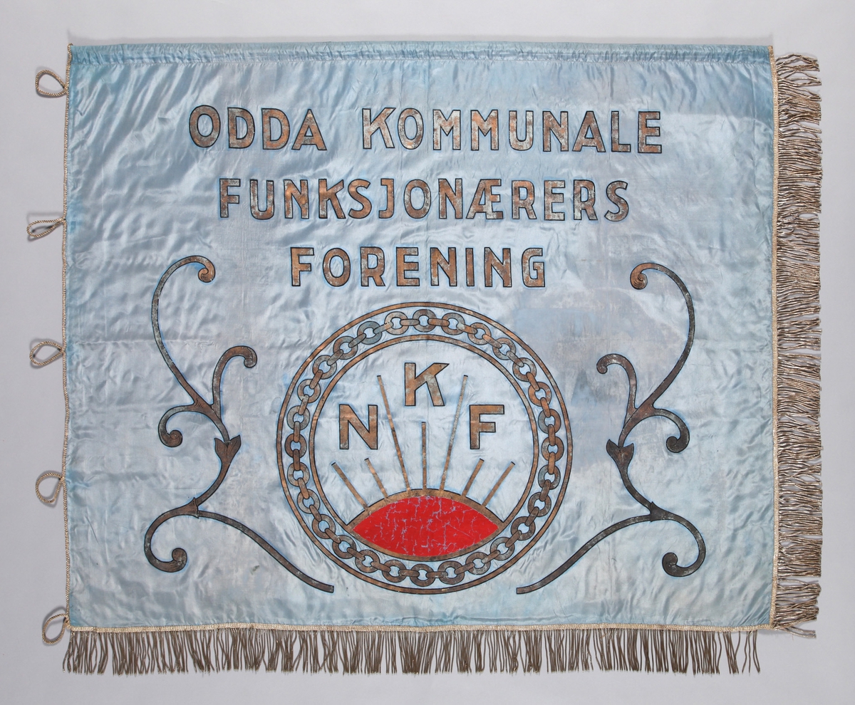 Hovudmotiv: Logo/emblem for NKF (Norsk Kommuneforbund); oppstigande raud sol, lenke i sirkel rundt. Stiliserte liljerrankar på sidene av emblem. Likt på båe sider.