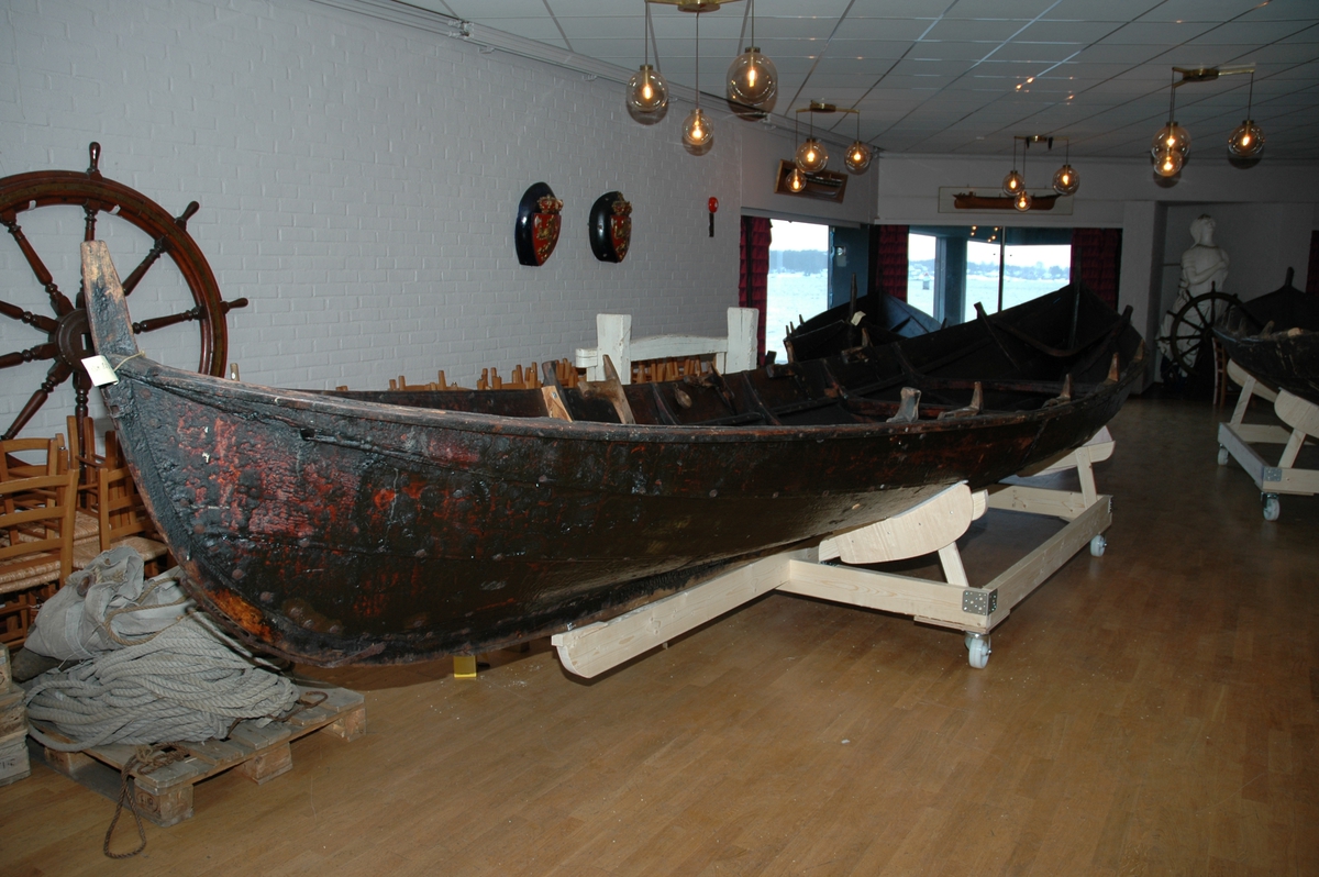 Åttring med nyere reparasjon. Fire keiper, et par årer, fem tiljer, tre tofter, ror, styrvol, mast og seil.