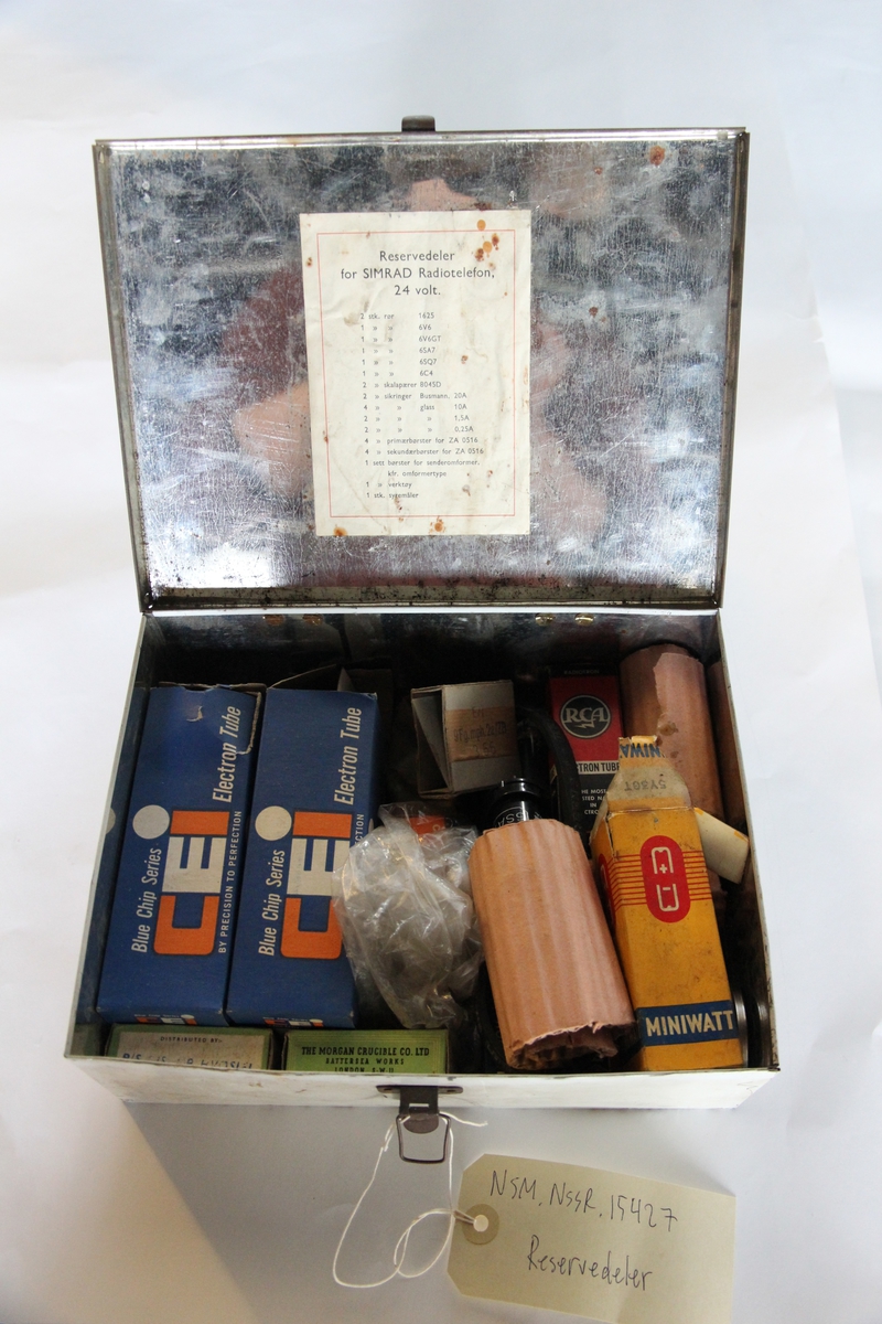 Boks av blikk innholdene diverse reservedeler til radiotelefon.