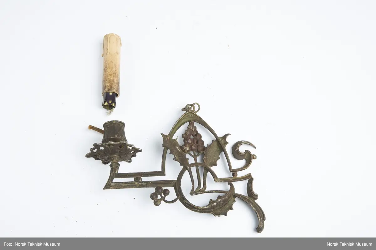 Lysekrone / hengelampe i metall for sju lys (seks lys + ett i midten). Lampa er ødelagt og i mange deler, oppheng, løse pæreholdere, glassbeholder, kuppel etc.