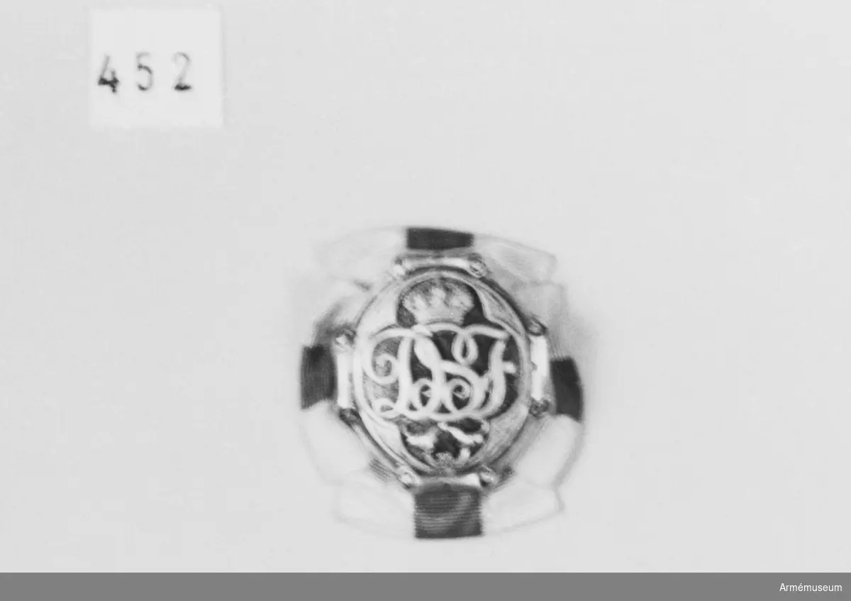 Brosch av förgylld silver och blå emalj. Med drottning Sophias initialer "D S F" krönt med en kunglig, sluten krona. Kronan är fylld med röd emalj.

Bokstävernas höjd: 14 mm. På ramen kartuscher.

På baksidan är broschnålen genomstucken ett band i rött och vitt ripsband som är förenad som en rosett och synlig från framsidan 7 mm.

På baksidan stansat "G.Möllenborg Kongl.Hovjuvelerare Stockholm.