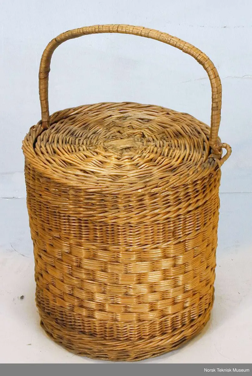 Termosaktig flettet kurv med håndtak og lokk.
Håndtaket er løst.