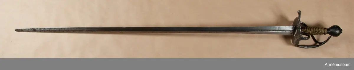 Klingan märkt med P-stämpel och "(CO)". Bredd vid fästet: 34 mm.

Fästet med upp-/nedvänd, äggformig knapp m icke ursprunglig låg nitknapp. Kavellindning av snodda mässingstrådar i reglementsenligt mönster är av senare datum. Randad, flat, svärtad parerplåt; något mindre på insidan än på utsidan. Dess kant är svagt runduddad och den undre sidan har en ornering i form av radialt ordnade ränder. "Nr: 191" inputsat. Handbygeln m förtjockning på mitten är intappad i knappen. Från parerplåten utgår en svängd, yttre sidobygel och ansluter till handbygelns övre del. Parerstången nästan rakt utstående m ett droppformigt avslut. Från parerplåtens insida utgår vertikal tumbygel. 

Klingan tveeggad m flat ås och hålslipning på bägge sidor. I dessa äro inslagna otydliga bokstäver "(CO)" och P-stämpel.