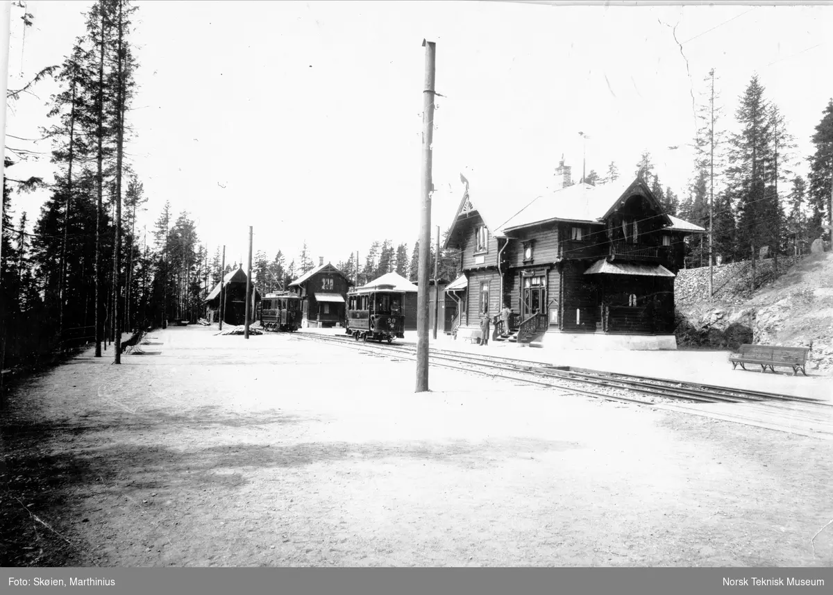 A/S Holmenkolbanen: Holmenkollen Stasjon, nytt navn i 1919 Besserud St. Motorvogn no 12, tilhenger no 17 og 20 fra Schuckert, 1898. Bygninger fra venstre: vognskur, skysstasjon, godsskur og stasjonsbygning. Ca 1900