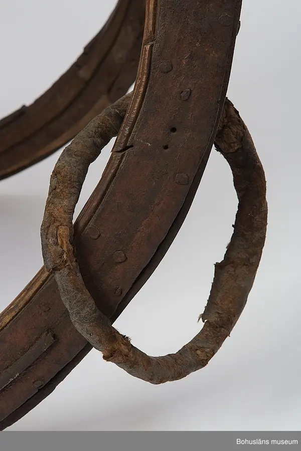 Rikt utskuren slädkorg i (norskinspirerad) rokoko på svängda medar som går ihop framtill. Målad med brunt, engelskt rött och guld.
Runt en av medarna är en ring av ihopsytt läder med rep inuti.
Längst upp är en duva utskuren samt målad med guldfärg.
Sidostycken med målade pannåer föreställande medaljonger med blomkvist samt rosett upptill i grönt, rött, vitt mot brun bakgrund.
Målad inuti med engelskt rött.
Järnet har bladslingor gjutna i relief.
Vissa delar är sekundära.

Se Knut Adrian Andersons "Katalog I, A. yngre föremål" under Uddevalla museum/förening D 2A:1.

Ur handskrivna katalogen 1957-1958:
Släde (förmodl. felident. tidigare)
L. 2m. Snidad i rokokostil m. målade medaljonger; huvudsakl. rödmålad; längst fram en duva, skuren i ek. Järnbeslag rostiga, smärre defekter, skrangliga.