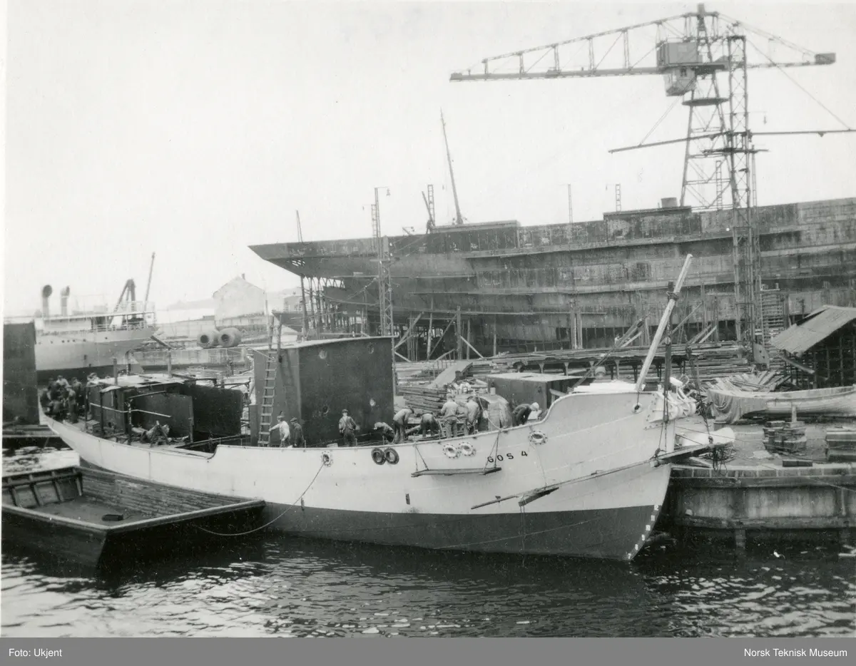 Eksteriør, hvalfangstskipet D/S Gos IV (senere omdøpt til D/S Antonio Vera), B/N 435 under bygging til kai ved Akers Mek. Verksted 14. August 1928. Skipet ble levert av Akers mek. Verksted i 1928 til A/S Hvalfangerselskapet Pelagos (Bruun & von der Lippe), Tønsberg.