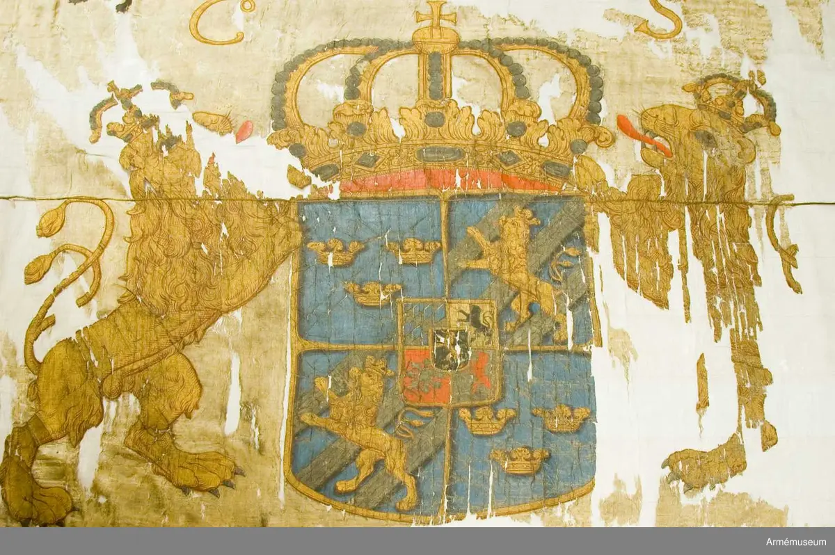 Fanduk av fyrskaftat kyprat siden med målade emblem, omvänd lika på båda sidor; svenska riksvapnet under pfalziska huset i guld, silver och färger, hållet av tvenne dubbelsvansade lejon, skölden guldkantad, krönt av en stor, sluten kunglig krona i guld med rött foder, samt stenar och pärlor i silver. Lejonen av guld med röda tungor, krönta med slutna kungliga kronor.

I båge över vapnet C.R.S. I övre inre hörnet Västergötlands sköldemärke: ett lejon till hälften i guld och till hälften i svart, följt av tvenne silverstjärnor. Målad av trofémålare Olof Hoffman.

Stång av brunmålad furu, 3,58 m lång. Spets saknas.