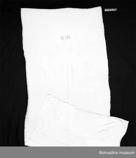 594 Landskap BOHUSLÄN

Ihopsytt av två tygstycken. Text i den övre kantens mitt: "K1A" broderat i rött). K= Kvinns.