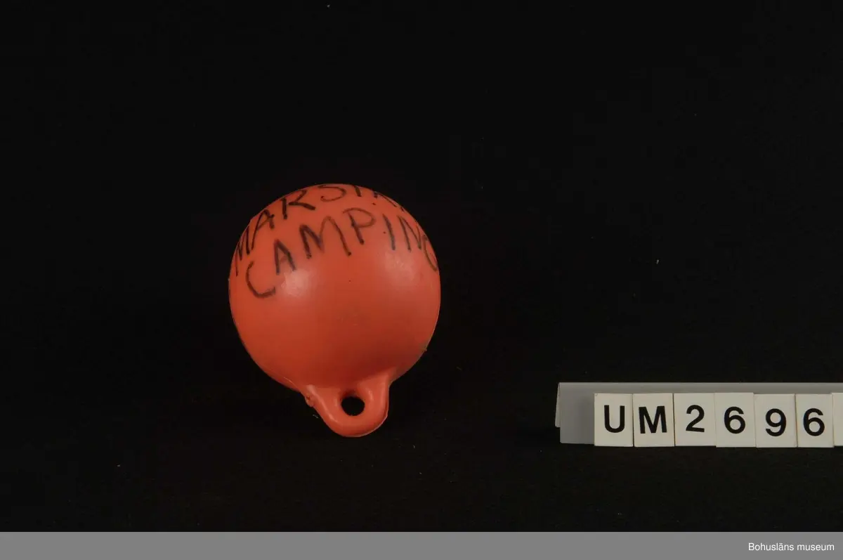 Föremålet visas i basutställningen Kustland,  Bohusläns museum, Uddevalla.
410 Mått/Vikt OMKRETS 68; 48,5; 40,5 CM
594 Landskap BOHUSLÄN
503 Kön MAN

Flöten i form av starkt gulrödfärgade (orange) plastklot med två utstickande runda öglor på ett ställe och på motsatta sidan en långsträckt  upphöjning på ytan. 3 st i olika storlekar.
På det största flötet står svagt skrivet med tuschpenna: OBYBERG, RÖRTÅNGEN samt tel nr dit.
 I öglorna på flötet av mellanstorlek är ett polyester?snöre fastsatt.
På det minsta flötet står skrivet med svart tuschpenna: Kent Wegelt. MARSTRANDS CAMPING samt tel nr.
Flötena är med all sannolikhet från sent 1900-tal.
Plastflötena i gåvan är delvis vrakade. I kommentar till beslutet att ta in dem i museets samlingar står: Intressant p g a anskaffningssätt - de är vrakade.
Smutsiga.
Föremålen UM26962 - UM26970 har tillhört Tage Samuelsson, f 1910, d 1998, bosatt på fastigheten Fridhem på Lövön, Kode, Solberga  socken. (Lövö ligger en bit ifrån Kode men detta är den uppgift som fanns på insamlingsblanketten).
Tage Samuelsson var trädgårdsmästare och husbehovsfiskare. Han rodde  till Marstrand med trädgårdsprodukter. 
Till gåvan hör också arkivmaterial se arkivnummer 389 i Bohusläns  museums arkiv.