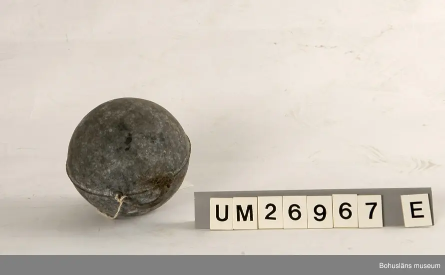 Fem klotformade flöten av metall (aluminium eller zink?). Beskrivningar av flötena i storleksordning följer här:
1. Omkrets 64 cm, med tre upphöjda ränder runtom på mitten och korta upphöjda ränder på tvären mellan dem på några ställen. I utstickande rektangulär del med rundade hörn finns två runda hål bredvid varandra. Text i relief: MANUFACTURERS PHILIPS ...(Oläsligt) TRAWL PRODUCTS GRIMSBY? ENGLAND ? (Svårlästa ord). Oläslig text p g a att den är bortsliten även på ytterligare ett ställe. Slitet.
2. Omkrets 63,5 cm, med sju upphöjda ränder, den mittersta bredare än de övriga. Två rundade metallöglor med gemensam mittdel sticker ut. Text i relief: AUTRIEB ? (Svårläst)...(Oläsligt) Märke som ser ut som ett kantigt stort S och siffrorna 197. Mycket smutsigt, fläckvis vit beläggning.
3. Omkrets 63 cm, slät yta utan upphöjningar, målad i vitaktigt grönblått i två olika nyanser, färgen delvis avsliten. Utstickande del med två närmast fyrkantiga hål. Text i relief: ... (Oläsligt ord) DE ... (Oläsligt ord) PARIS. Stor rostfläck. Mycket slitet.
4. Omkrets 55,5 cm. Med fem upphöjda ränder runtom. Rundad del med två kvartcirkelformade hål sticker ut. Text i relief: MADE IN SPAIN LA CORONA, bild av en fyr med ljusstrålar samt patentnummer med 39 siffror i. Samma? text/bild/siffror finns på ytterligare ett ställe fast är där mer sliten. Slitet.
5. Omkrets 37 cm. En upphöjd rand på mitten, för övrigt slät yta. En ögla sticker ut på ett ställe. Knutet runt den finns rester av snöre. Slitet. Rostfläckar m fl fläckar.

För uppgifter om brukaren se UM026962
Se även Bohusläns museums arkiv, arkivnummer 389.