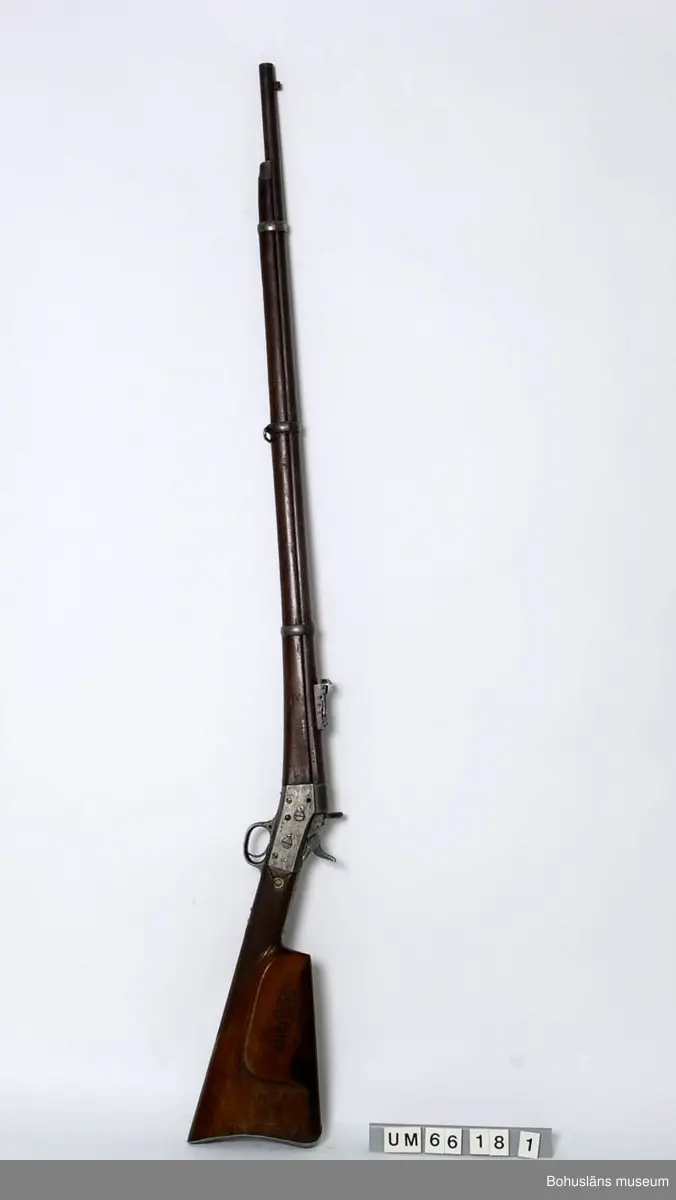Ägt i många år av fru Elmhedens fader,  Anders Gustan Hallberg, Håby.

Remington 1888.
Längd: 136 cm
Vikt ca 4,25 kg
Pipans längd 94,5 cm
Krinmärkt.
6 refflor.
m/1868
Mekanismens vänstra sida: 1867 (tillverkningsår?)
Mekanismens högra sida: 1441
Pipan: 5676

Ur punktnummerkatalogen 1958-1976:
Fru Linnéa Elmheden
Krongevär, Remington

Se Placering.