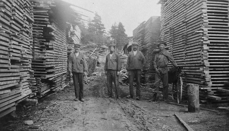 Enligt medföljande text: "Detta foto visar när stockarna har sågats till bräder och plank vid Stöttens sågverk och upplagts av Albert Alfredsson, Bergetorpet. Gustaf, Johannes och Albin. "När jag betraktar dessa 10 fotografierna så är det endast ett fåtal av dessa dugliga arbetare som lever år 1976. Frid över deras minne!".