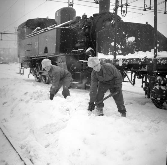 Enligt notering: "Värnpliktiga skottar snö på järnvägen jan -58".
