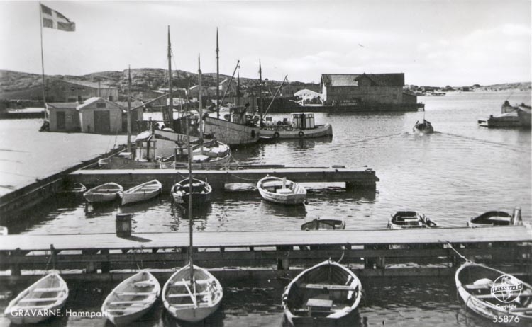 Tryckt text på kortet: "GRAVARNE. Hamnparti".
Noterat på kortet: "GRAVARNE ASKUMS SN. S. SOTENÄS(ET) 24 Juli 1955"
"Småbryggor vid ångbåtsbryggan i G. 1950".