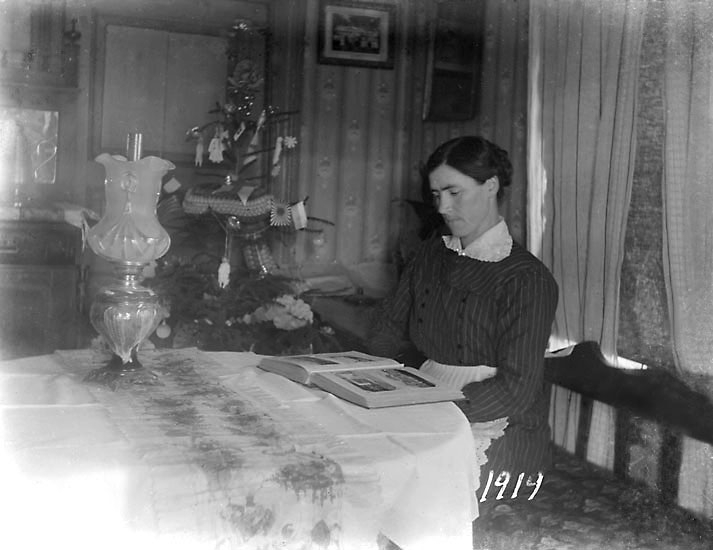 "Julen 1919. Klara tittar i fotoalbum."