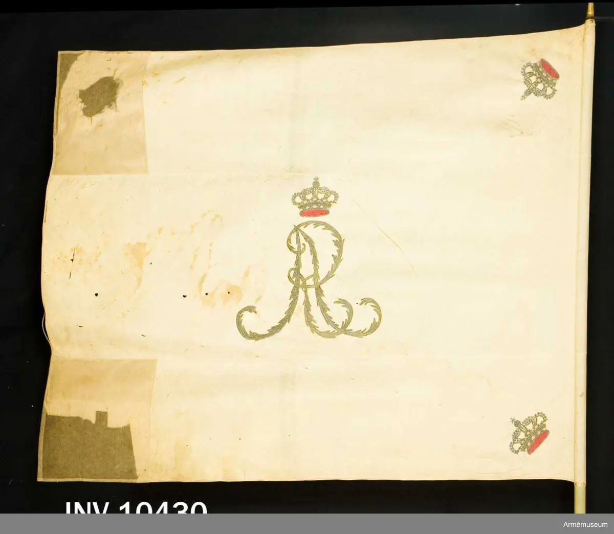 Fanduk av vit sidenkypert i tre våder, broderad med guld omvänt å båda sidor: I mitten Gustaf IV Adolfs namnchiffer "GA" under kunglig krona med foder av rött silke samt stenar i olikfärgat silke. I hörnen slutna, kungliga kronor liknande namnchiffrets. Duken är kantad med vitt sidenband, fäst med vitt sidenband och förgyllda spikar. Stång av furu, gråvitmålad. Diameter - ovan fanan 3 cm, nedom 3,5 cm. Holk av förgylld mässing.
Märkt "L.G." på stången.