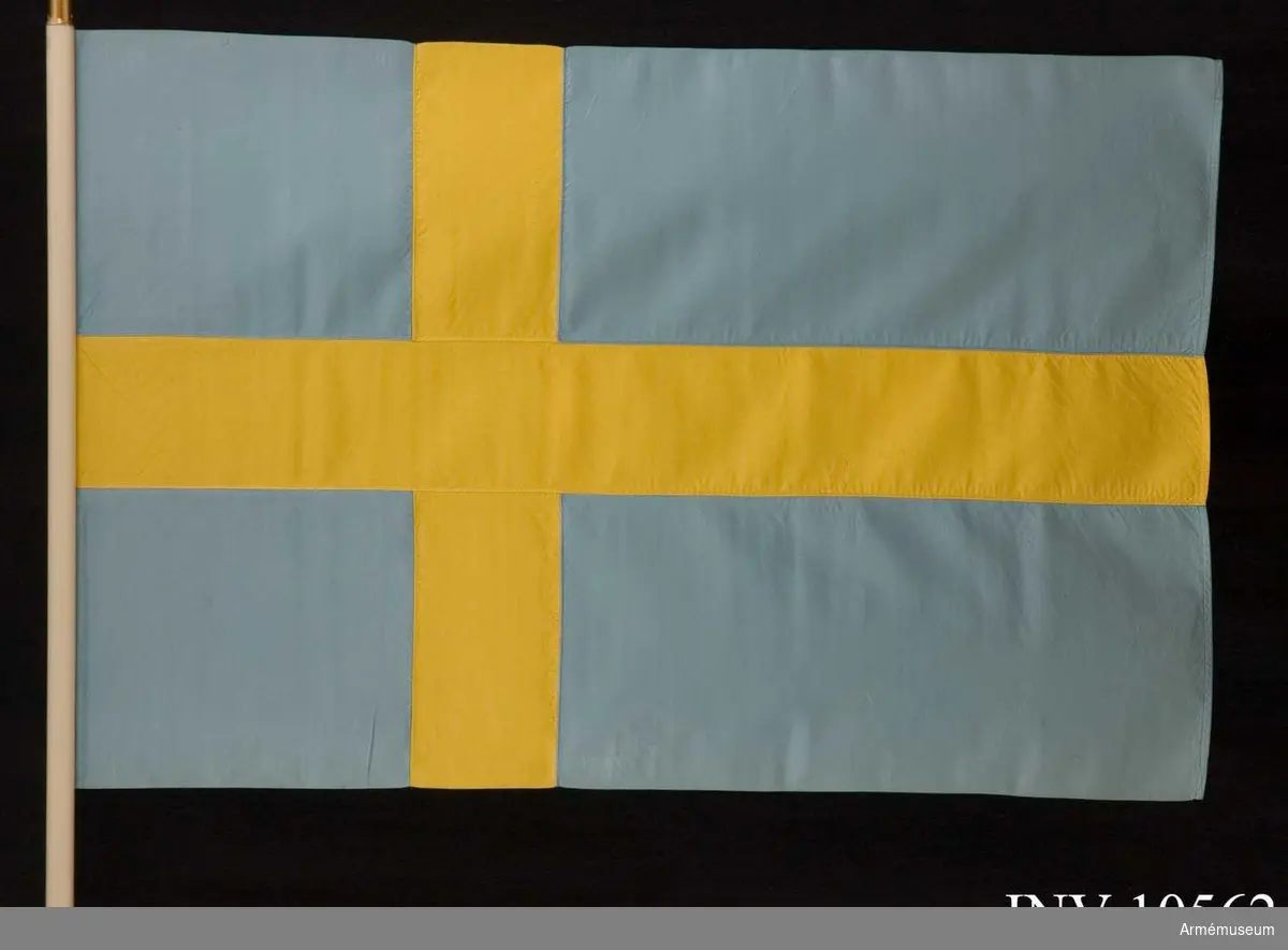 Grupp B I.

Duk av blått och gult siden, s k korsflagga. Fodral av blått kläde är märkt på den undre fickan: "Int 2". Fickan innehåller spetsen med Gustav V:s namnchiffer.