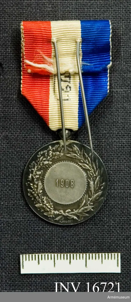 Medaljen är monterad på ett ripsband i Frankrikes färger, rött, vitt och blått. Framsidan visar segergudinnan och runt kanten står Republique Francaise. Baksidan har i mitten en slät cirkel med årtalet 1908. Cirkeln är omgärdad av lagerkvistar. Medaljen är tilldelad Carl August Malmsten, fanjunkare. Samhörande dekret från Ministere des affaires étrangeres.

Samhörande nr är AM.16715-16732