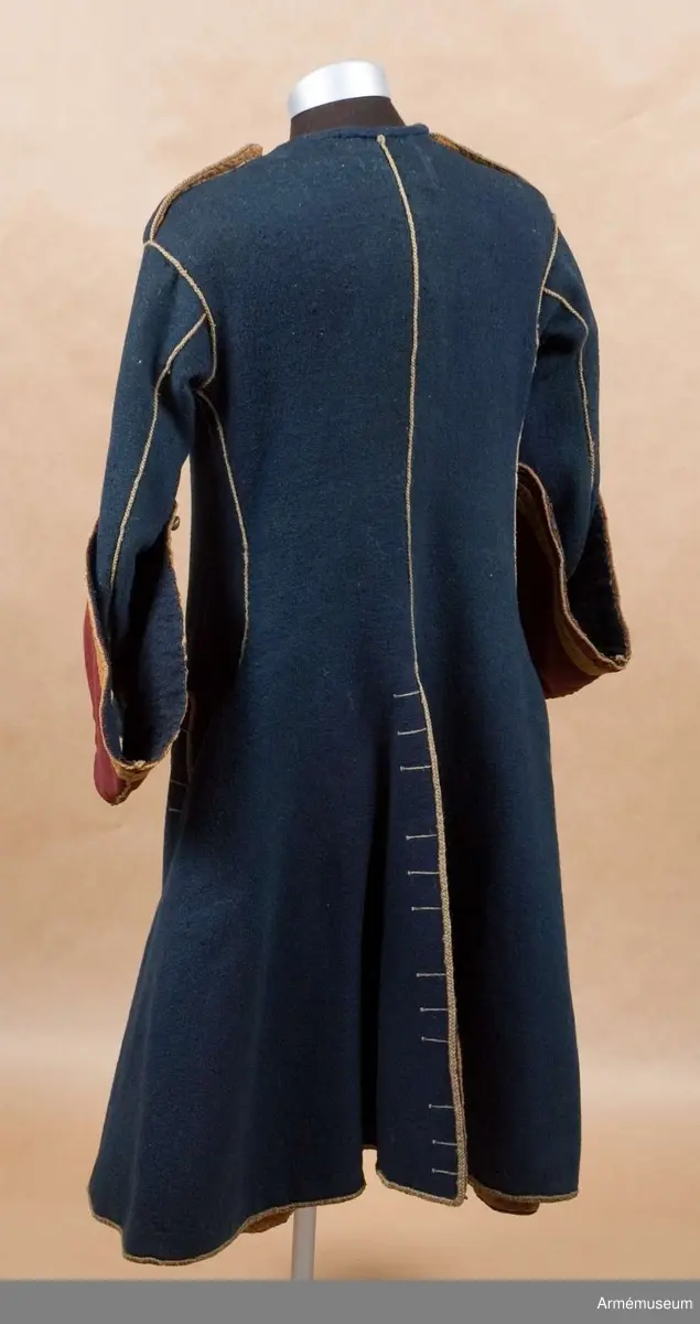 Grupp C I.
Uniformsrock-, Frankrike. Justaucorps, sannolikt 1680-t. Antal knappar i original: Knäppning mitt fram 23 st (ursprungligen 24). Rockens vänstra sida 4 st (urspr 6), den högra sidan 6 st, vänster yttersida 4 st (urspr 6), höger yttersida  3 st (urspr 6). Vänster och höger axel 1 st på var. Vänster och höger ärm 4 st  på var ärm. /AA nov 1986.