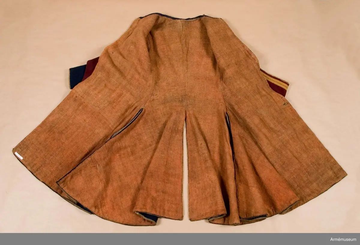 Grupp C I.
Uniformsrock-, Frankrike. Justaucorps, sannolikt 1680-t. Antal knappar i original: Knäppning mitt fram 23 st (ursprungligen 24). Rockens vänstra sida 4 st (urspr 6), den högra sidan 6 st, vänster yttersida 4 st (urspr 6), höger yttersida  3 st (urspr 6). Vänster och höger axel 1 st på var. Vänster och höger ärm 4 st  på var ärm. /AA nov 1986.