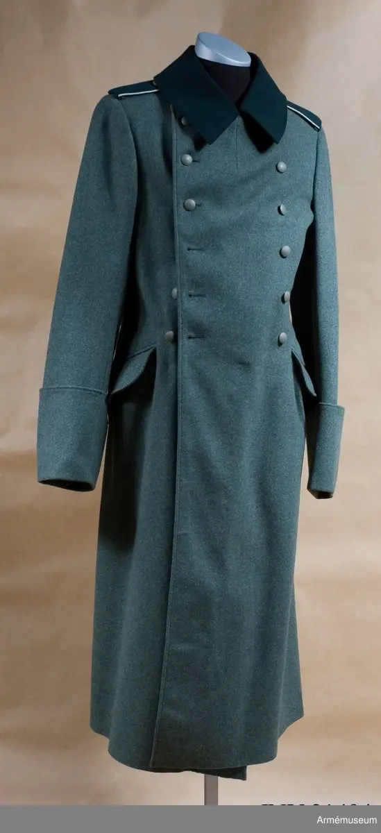 Överrock (1937) för menig vid infanteriet. Av fältgrått kläde. Tvåradig med 6 knappar i vardera rad. Baktill en inskärning som knäpps med 4 benknappar inuti, i livet en sleif som består  av två delar. Axelklaffar av mörk grönt kläde med vit passpoil omkring, b:45 mm. Foder av grått tyg. Knappar av grå metall. Ärmuppslag rakskurna, h:160 mm.