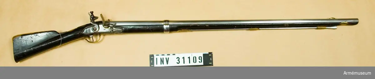 Karbin med flintlås.
Vapnet överensstämmer helt med A.M. 31074. På pipans översida finns Jönköpings krönta ring i två olika storlekar, en stämpel med P.RS (vål Peter Rundberg, men bokstäverna kunna vara PRC) samt desutom numret 122. På undersidan sitter Jönköpings krönta ring, vilken, liksom på översidan, är mera kronliknande än vanligt.

På låsbleckets utsida finnes en stämpel med S.L och med månguddig stjärna. Till vänster om varbygelns främre arm sitter på stockens undersida ett stockmaka remärke, bestående av bokstäverna DG. Baktill på kolvens vänstra sida är numret 122 inslaget. På bakplåtens flik, på karbinstångens bakre arm samt på varbygelns bakre arm finnes samma stämpel som på låsblecket. På bakplåtens flik är desutom numret 122 inslaget. På sidbleckets insida finnes en stämpel med bokstäverna C.S. På laddstockens stötyta är ett B inslaget. Se i övrigt A.M. 31074.