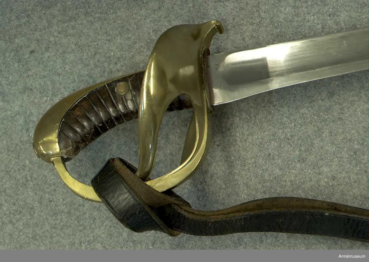 Stålklinga med ässingsfäste och läderklädd kavel.