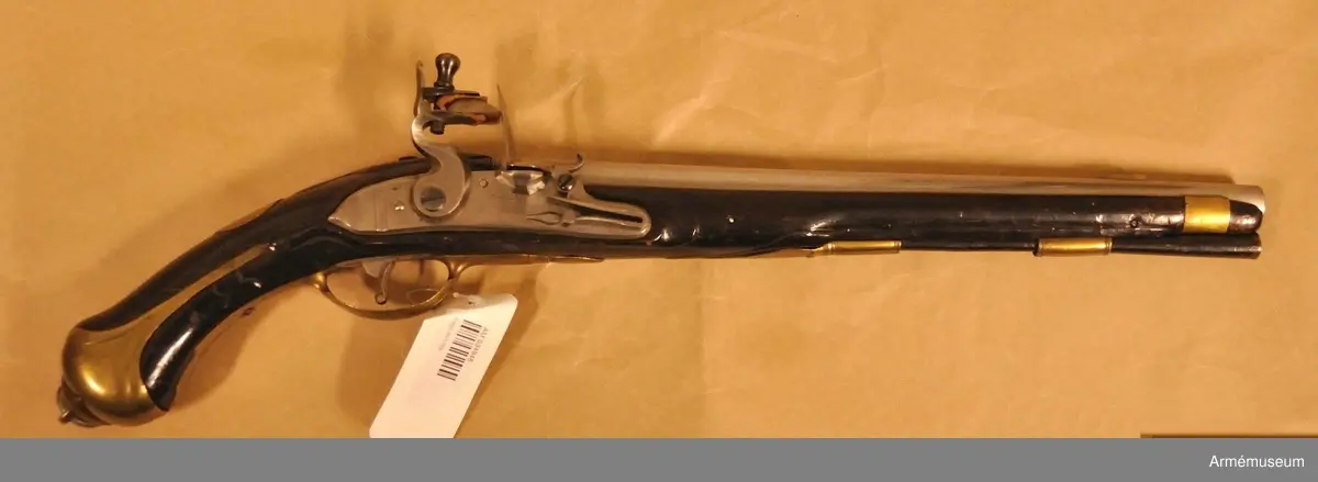 Pistol med flintlås.
Beslag av mässing. Laddstock av trä med mässingsbeslag. På kammarstycket ett krönt F samt bokstaven Ö. På kolvhalsen en mässingsmedaljong med Gustaf III:s krönta namnschiffer. På kolvhalsens H sida nummer 25 inskuret och på dess motsvarande bokstäverna V B. Vid kolvknappen en ring av järn fästad, pistolen tycks vara par med AM 1932:4769.