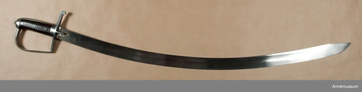 Klingbredd upptill: 36 mm. Klingan är krökt samt på större delen av sin längd eneggad och skålslipad. Udden sitter nära nog i klingans mittlinje. På en längd av omkr 31 cm från udden har klingan egg även på rygg-sidan. Upptill på yttersidan står "ZETTERBERG" och upptill på innersidan är en stämpel med bokstäverna C. F. K. inslagen.

Fästet är av järn. Tången är bred, och vid den är på var sida en skena av mörkt trä anbringad, vilka båda skenor fasthållas av tre genomgående nitar. Nederst omgives kaveln av ett ringliknande, 1,1 cm järnbeslag. Baktill har kaveln ryggbeslag, som uppåt övergår i en låg avrundad kappa. Tångens översta del fasthålles av en påskruvad, åttkantig liten mutter, som sitter ovanpå kappan.
Parerstången är rak och har fyrsidigt tvärsnitt. Baktill avslutas den av en nedböjd knapp. Upptill på parerstångens bakre arm är siffran 8 inslagen. Ett par små styrskenor, som har avfasade kanter och avrundade ändar, utgår från undersidan av parerstångens mitt.Från parerstångens främre ände utgår hanbygeln i tvär vinkel men går ej rakt uppåt utan snett framåt. Den har på framsidan snedfasade kanter. Handbygelns övre ände är instucken under kappans främre kant.