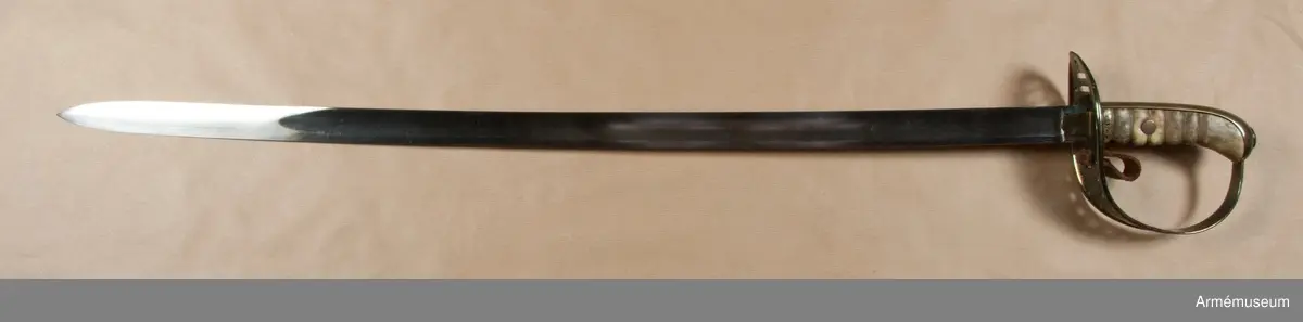 Klingan är till större delen av sin längd eneggad och skålslipad, men blir mot udden tveeggad och får ryggar. Klingbredd upptill: 31 mm. 

Fästets beslag är av mässing. Kaveln är klädd med vitaktigt läder och har sex räfflor. Genom den tredje nedifrån går en nit genom kaveln. Baktill har kaveln ryggbeslag, som upptill övergår i en avrundad kappa. På kappans översida finns en ganska stor, oval nitknapp. Nedtill går ett ringliknande mässingsbeslag kring kavel och ryggbeslag. 
Parerplåten är på det bredaste stället 9 cm. bred. Framtill slutar den i en liten snibb, som är lindrigt nedåtböjd. På undersidan är parerplåtens kanter förhöjda, men dessa förhöjningar slutar baktill en liten bit från den ovan omtalade snibben och fortsätter framtill in på handbygelns nedersta del. Framför kaveln finns två horisontala springor för handremmen och bakom kaveln genombryts parerplåten av två liknande springor för handremmen. Längs parerplåtens kanter, från springorna för handremmen till något under handbygelns mitt, finns vid varje kant 11 runda hål. Ovanför det översta hålparet sitter två hål i rad och längs bak, bakom springorna för handremmen, sitter ett ensamt hål. Från parerplåtens undersida går ett par rätt breda, nedtill avrundade styrskenor ut nedåt. På parerplåtens undersida bakom klingan står J. S. och F. B. 

Enligt anmärkning i 1888 års tryckta katalog skiljer sig detta vapen från projektmodellen, AM 39853, genom att fästet är rymligare.