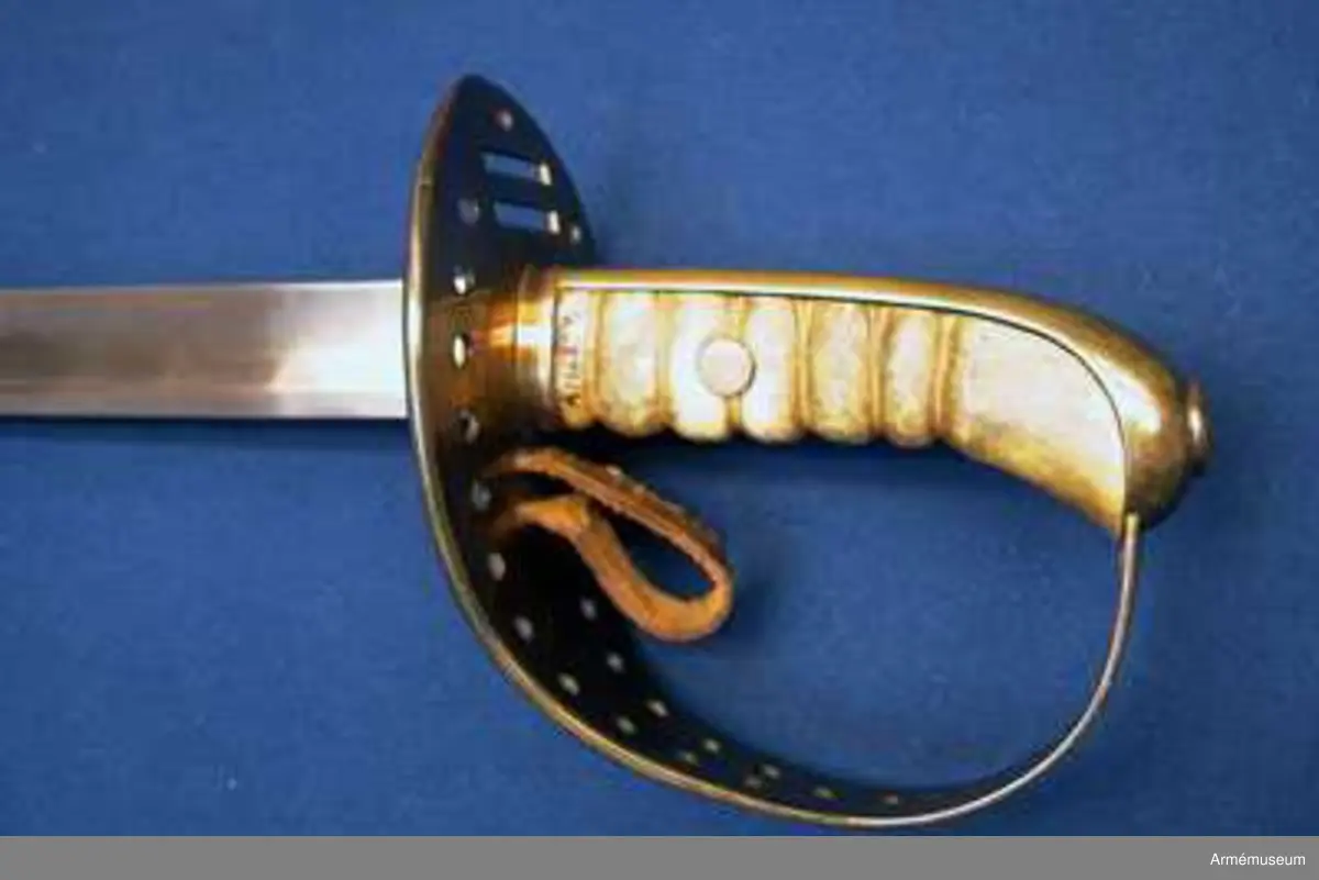 Klingan är till större delen av sin längd eneggad och skålslipad, men blir mot udden tveeggad och får ryggar. Klingbredd upptill: 31 mm. 

Fästets beslag är av mässing. Kaveln är klädd med vitaktigt läder och har sex räfflor. Genom den tredje nedifrån går en nit genom kaveln. Baktill har kaveln ryggbeslag, som upptill övergår i en avrundad kappa. På kappans översida finns en ganska stor, oval nitknapp. Nedtill går ett ringliknande mässingsbeslag kring kavel och ryggbeslag. 
Parerplåten är på det bredaste stället 9 cm. bred. Framtill slutar den i en liten snibb, som är lindrigt nedåtböjd. På undersidan är parerplåtens kanter förhöjda, men dessa förhöjningar slutar baktill en liten bit från den ovan omtalade snibben och fortsätter framtill in på handbygelns nedersta del. Framför kaveln finns två horisontala springor för handremmen och bakom kaveln genombryts parerplåten av två liknande springor för handremmen. Längs parerplåtens kanter, från springorna för handremmen till något under handbygelns mitt, finns vid varje kant 11 runda hål. Ovanför det översta hålparet sitter två hål i rad och längs bak, bakom springorna för handremmen, sitter ett ensamt hål. Från parerplåtens undersida går ett par rätt breda, nedtill avrundade styrskenor ut nedåt. På parerplåtens undersida bakom klingan står J. S. och F. B. 

Enligt anmärkning i 1888 års tryckta katalog skiljer sig detta vapen från projektmodellen, AM 39853, genom att fästet är rymligare.