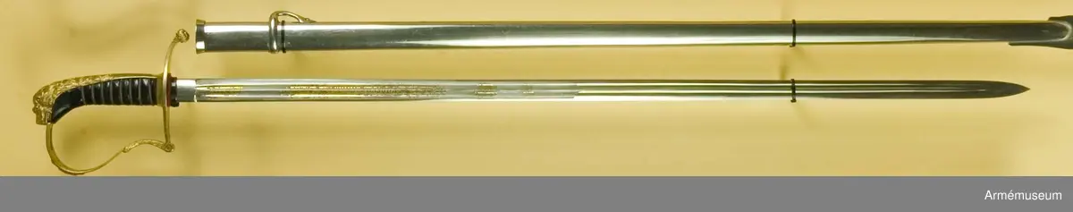 Klingbredd upptill 222 mm. Sabeln är fullkomligt AM 39928 men klingan är kortare. Den officiella längden på klingor m/1899 är 80 cm. Vid vapnet är fästat en fastställningslapp.