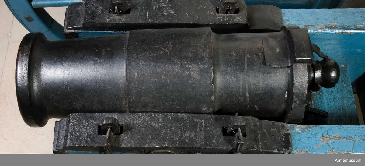 Mått: BOTTENSTYCKET Bottenstyckets största diameter 24,5 cm, Bottenstyckets minsta diameter 24,5 cm, Kammarsiraternas bredd 5,5 cm, TAPPSTYCKET Tappstyckets diameter ca 28,5 cm, Tappstyckets läge 23,5 cm, Tappstyckets bredd 25,5 cm, Tappskons läge 32,5-33 cm, Tappläge I 34 cm, Tapplängd 9,5-10 cm, Tappdiameter 9,5 cm. LÅNGA FÄLTET Långa fältets största diameter 26 cm, Långa fältets minsta diameter 23 cm, Trumfens största diameter 28,5 cm.

Haubitsen är ett enkelt eldrör, med förtjockat tappstycke. Druvan är platt-kulformig. Bottenstycket. På kammarsiraterna finns ett runt, genomgående hål för riktinstrumentet samt 2 st mötande, mindre hål, för instrumentets fasthållande (det undre av dessa är gängat, men skruven saknas). Fängpannan är nedsänkt, skålformig, strax framför kammarsiraterna. Omkring fängpannan inskriptionen  (inristat) I. XV. V:. N.Tappstycket. Tappskivans form samt tappens placering på denna, vänstra tappen sedd från vänster, se bilaga. Den vänstra tappen bär årtalet 1816, den högra tappen är märkt  ÅB, båda i rundrelief. Långa fältet. Trumfen, trumpetförstärkt (mycket kort trumpet). Omkring själva mynningen finns en stämpel, se bilagan.