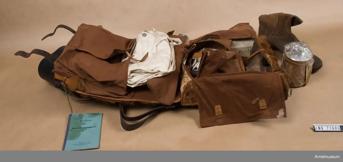Innerhåller stövlar m/1884, långkalsonger m/1903, instrumentbok, tre delar till tältstång, tältpinnar, två matpåsar tre dosor för fett, en påse i kläde, ett kokkärl och en konserv. 
En del av utrustningen är från år 1904.

I de två hörnen på locket finns små fickor för patroner och tältutredningen förvaras i ett separat fodral som knäpps fast under locket.

Stövlarna är märkta "3.G.R." på flera ställen och "1884". Sulorna är stämplade "29" och "9½". De är sydda med köttsidan utåt och sulorna är pliggade med träpligg samt försedda med klackjärn. På den ena stövelns hälla bak sitter en etikett med text: "Tyska stöflar bekommna år 1884".

Långkalsongerna är 115 cm långa, har en bakficka på högra sidan och en mindre framficka för fickur samt ett tygband för att fästa urets kedja. De är tillverkade i kypertvävd bomulls och har bomullsband vid anklarna och i linningen samt knappar för hängslen och i gylfen. Knapparna är tillverkade i zink. De är på insidan märkta "B.A.G. 1903". Urfickan och bandet i linningen daterar dem till m/1903.

Den vidhängande boken beskriver hur utrustningen ska packas. Boken heter: "Vorschrift über den gebrauch der Infanteriausrüstung m/95 (inf. U.)". Tryckt 1899 i Berlin.

Fodralet till tältdelarna är av m/1896 och tältstångdelarna samt tältpinnarna m/1902. Kokkärlet är av m/1910.

Dateringar och information enl. Ulrich Herr, The German Infantry from 1871 to 1914, vol. 1.