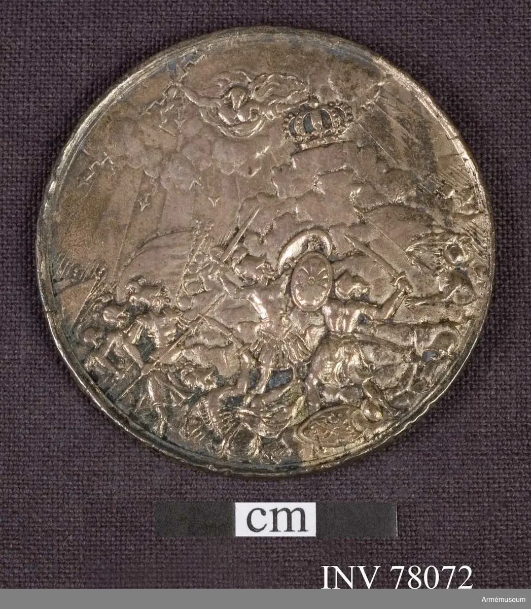 Grupp: M. 
Åtsidan: CAROLVS. XI. DEI. GRA: SVE.GOTH.WAND.REX. Bröstbild åt höger i lagerkransad kask med lejonhuvud över framsidan och fjädrar (plymer Prn), brämade mantelveck, fästade genom ett rutformigt smycke på axeln, därifrån nedhängande i veck - Nedanför: Meijbusch fecit.

Frånsidan: Utan inskrift, jupiter med åskviggen i högra handen på moln, ur vilka frambryta blixtar och breda ljusstrålar, skyddar med sin venstra hand en kunglig krona på toppen av ett högt berg, mot vilket krigare i antik rustning (jättarna eller titanerna) storma. En av kämparna i förgrunden bär en oval sköld, prydd med en rosett. På marken ligga slagna krigare och en sköld, innehållande ett Medusahuvud. Randskriften nästan utplånad.