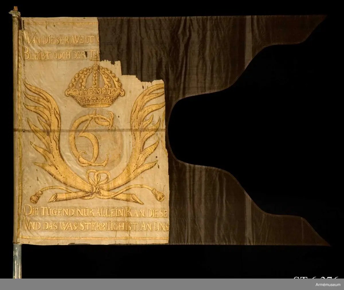 Dragonfana av vit taft med Christian 5's krönta monogram inom korsade palmkvistar. Allt målat i guld. En längre devis på tyska skriven i guldfärg ovan och under monogrammet.