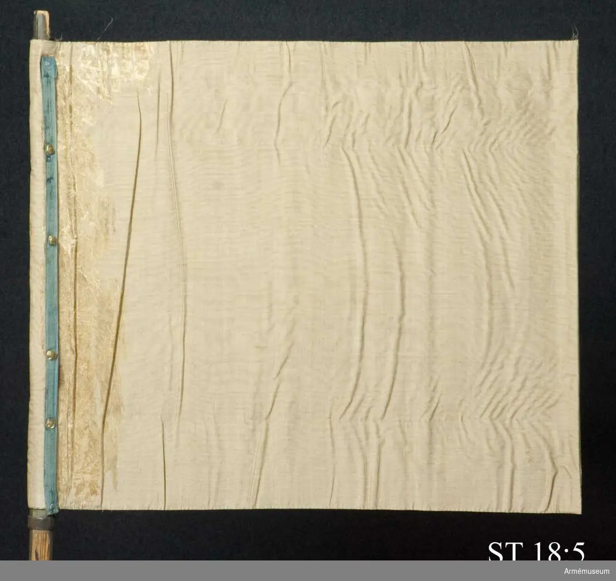 Standar vars motiv numer är försvunnet. Endast fragment vid stångsidan återstår. 

Spets saknas men enligt Hoffmans avbildning var den utformad som ett 6-ekrigt hjul - Maintz statsvapen. 8-kannelerad stång försedd med grepp och löparten och löpande bärring.

Inre sidan motiv numer försvunnet. Enligt H-J avbildning: Golgatascen med Maria och Johannes.

Yttre sidan delvis bevarad: Väpnad arm ur moln.