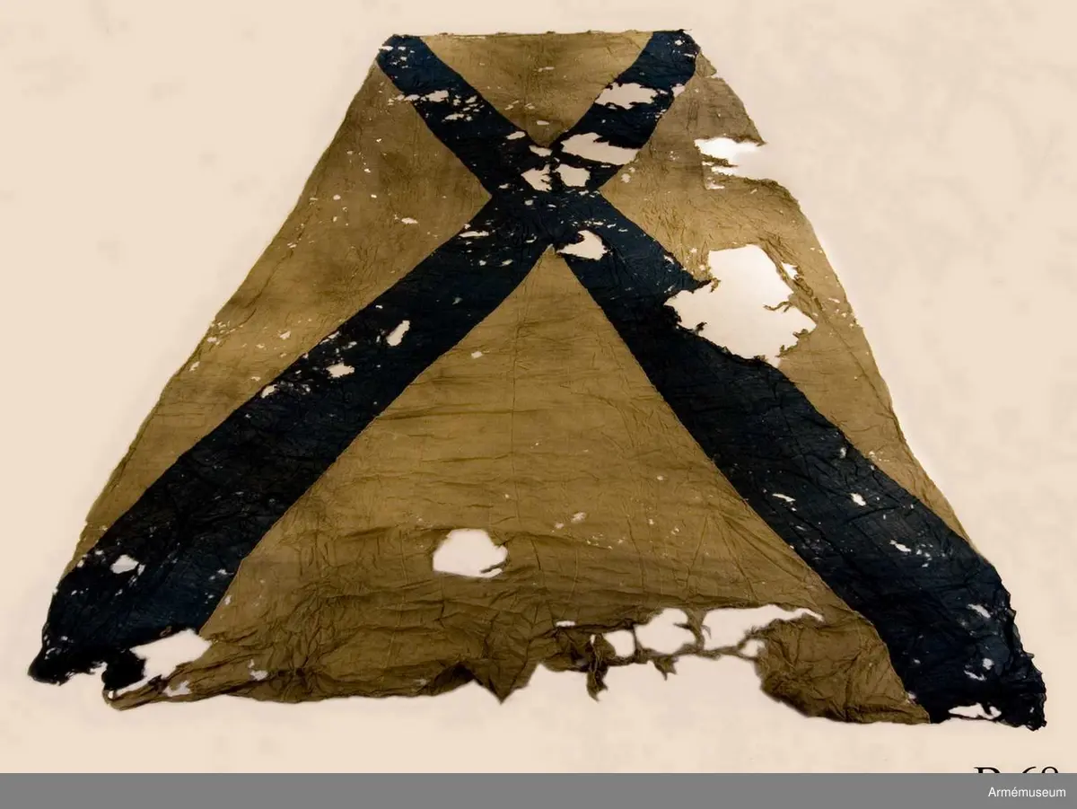 Flagga av flaggduk, sydd av 11 våder vitt tyg samt två våder blått i ett S:t Andreaskors. Vid stångsidan en förstärkning med snören som ska fästa flaggan i riggen. Även själva flaggan är förstärkt med extra lager blått tyg närmast stångsidan. En liten symbol broderad i vitt på det blå fältet.
Etikett av pergament med text: "No 19, Denna Ryska Flagga 11 Duk, är tagen uti Bataillen vid Svensksund under Hans Kungl. Maj:ts Egit Höga Befäl och Anförande 9. Juli 1790".