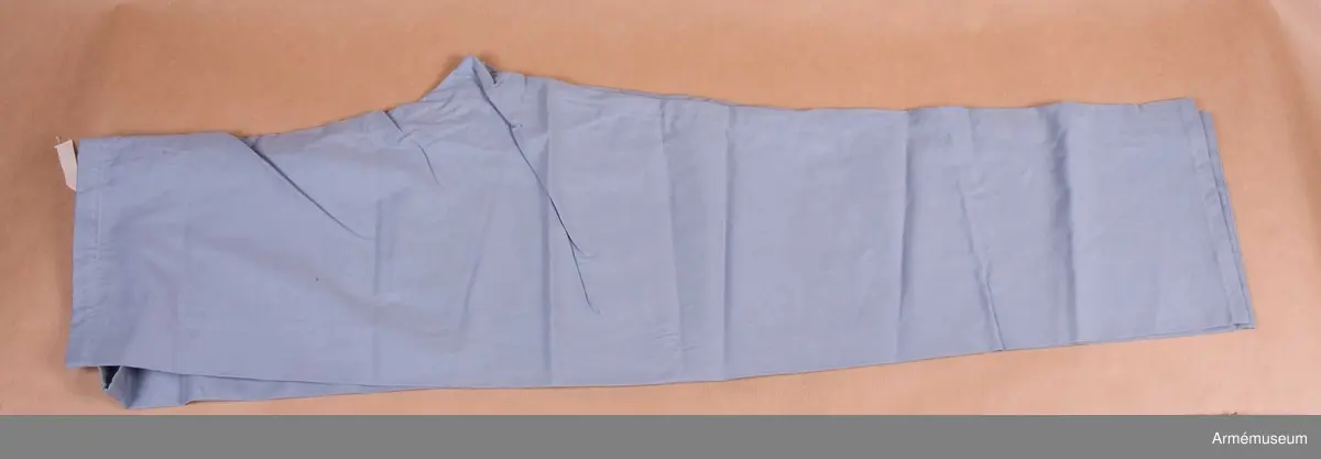 Vidhängande etikett: "Försvarets materielverk Fastställs M 7325-002000-8, Pyjamasbyxor, 1985-09-18 (oläslig underskrift)".