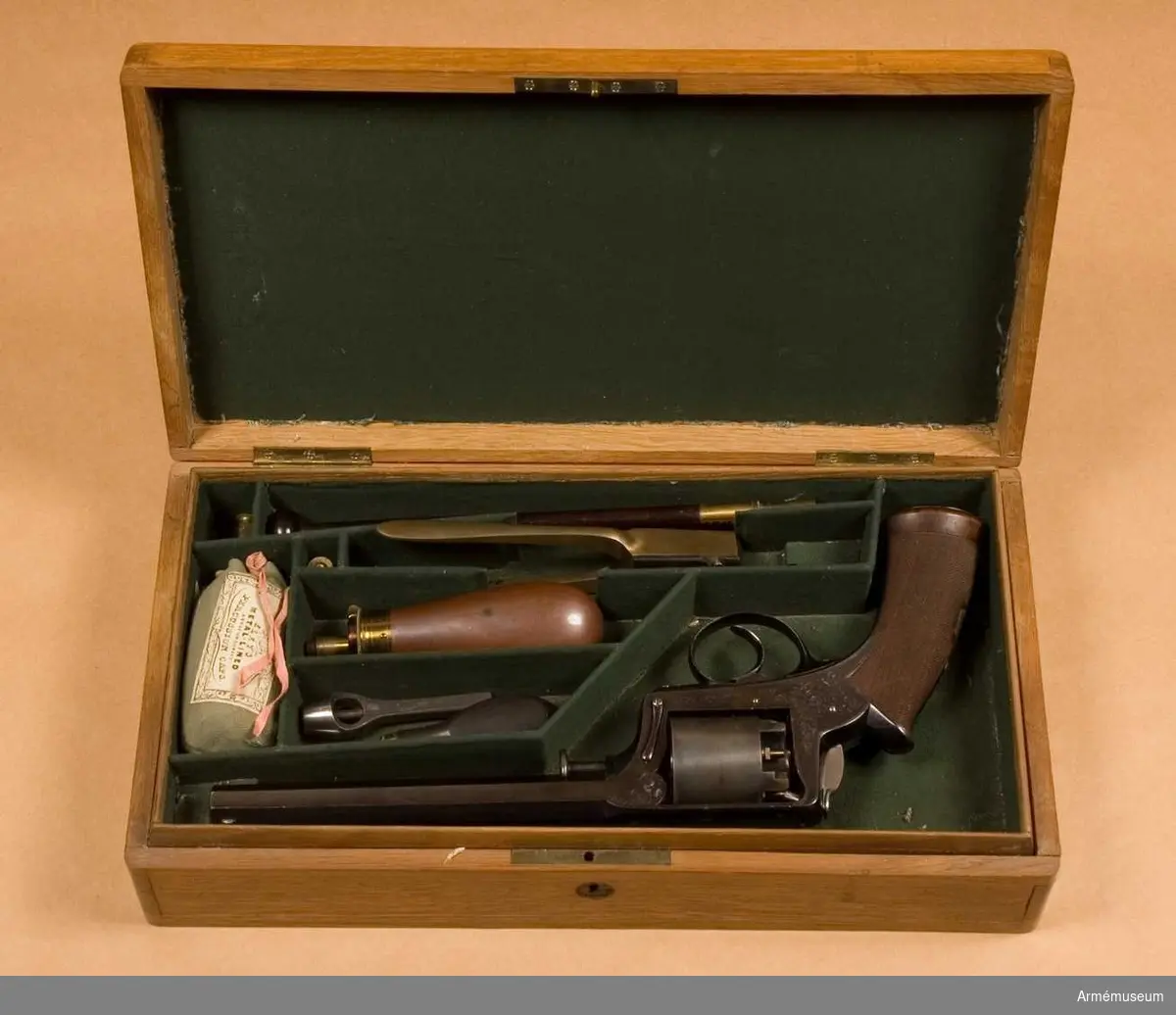 Grupp E: III.
Etui i ljus ek med omladdningpatroner.
Antal tillbehör i lådan: 9 st.
I etuiet ligger en påse med ca 160 g tändhattar.