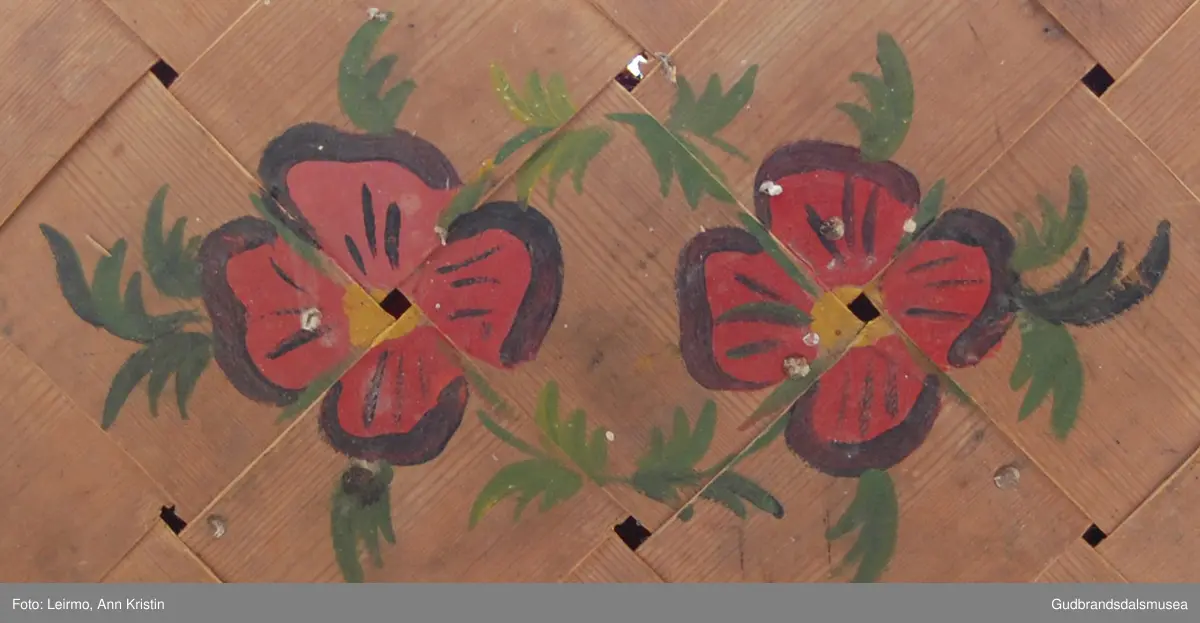 Rektangulær, flettet kurv av furu, håndtak av bambus, to håndtak samles til ett. Med låsemekanisme. Lokk festet til kurven med innslåtte metallkroker.