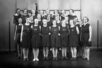 Jönköpings Gymnastikförening (JGF) i Västra skolans (nuvarande Talavidskolan) gymnastiksal. Föreningen bildades 1918.
Bakre raden: Astrid Nilsson g. Svensson(1), Rut Gran(2), Ingeborg Bruhn g. Bjurvik(3), Inga Örsell(4), Anna Lisa Brodén(5), Kerstin Henriksson g. Norman(6), Svea Eng(7), Rut Gustafsson(8).
Mellersta raden: Iris Lindblom(1), Margit Augustsson(2), Inga Lisa Holmér(3), Astrid Sandblom(4), Greta Nyström(5), Britta Andersson(6), Magnhild Augustsson(7), Stina Larsson(8).
Främre raden: Anna Andersson(1), Stina Vestberg(3), Elsa Holm g. Wallin(4), Gullan Johansson g. Nydén(5), Sonia Hellman(6).
Längst till höger ledare Marianne Herrlin.