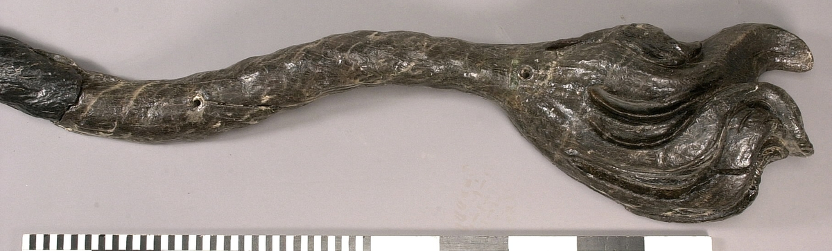 Skulpterad lejonsvans, lagad i rotändan. Svanstofsen är stor och yvig. Svansens baksida är slät.

Text in English: A sculpted lion''s tail, broken off where it was attached to the lion''s hind quarters. The tuft is large and bushy. The reverse side is smooth.