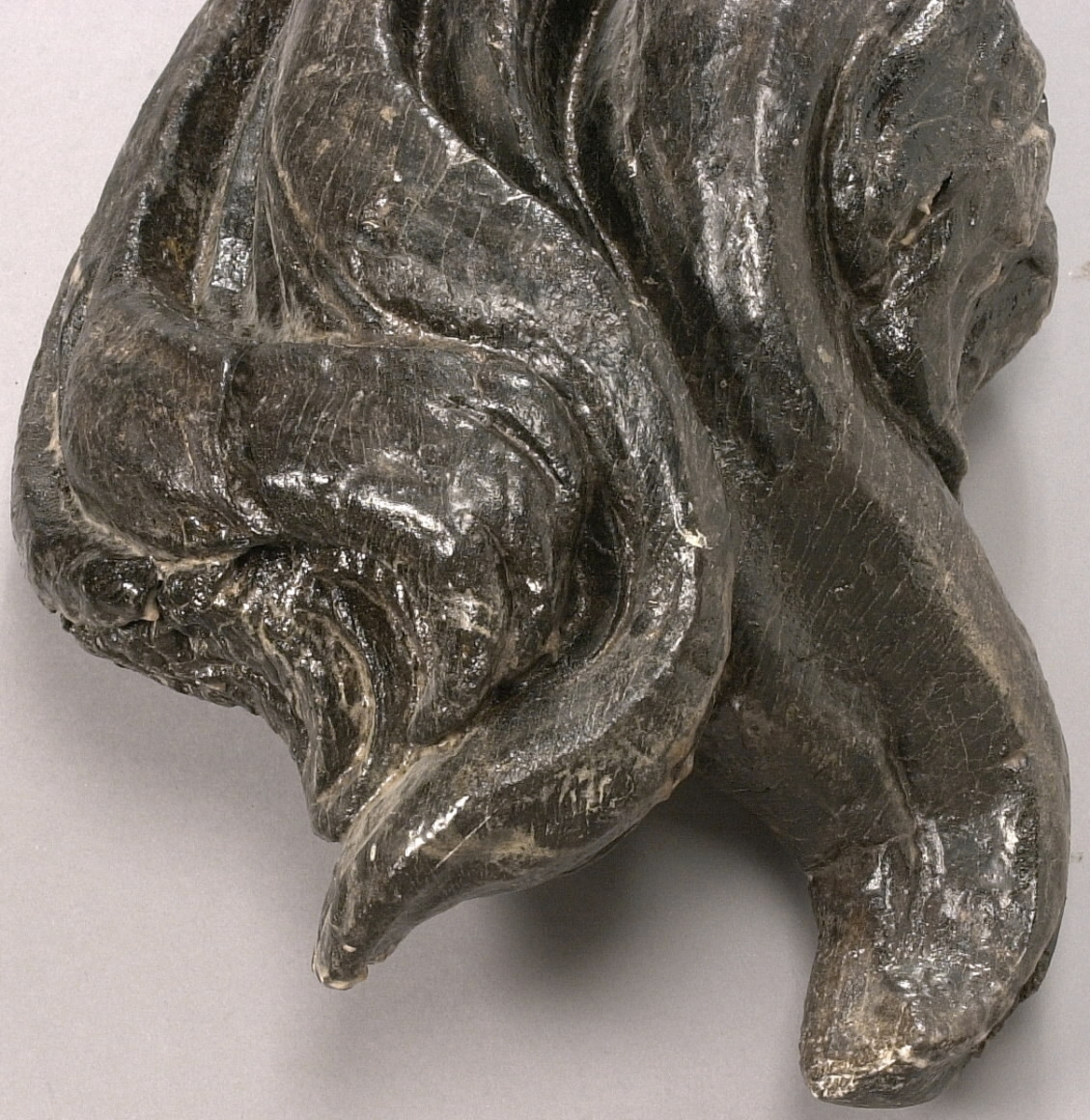 Skulpterad lejonsvans, lagad i rotändan. Svanstofsen är stor och yvig. Svansens baksida är slät.

Text in English: A sculpted lion''s tail, broken off where it was attached to the lion''s hind quarters. The tuft is large and bushy. The reverse side is smooth.