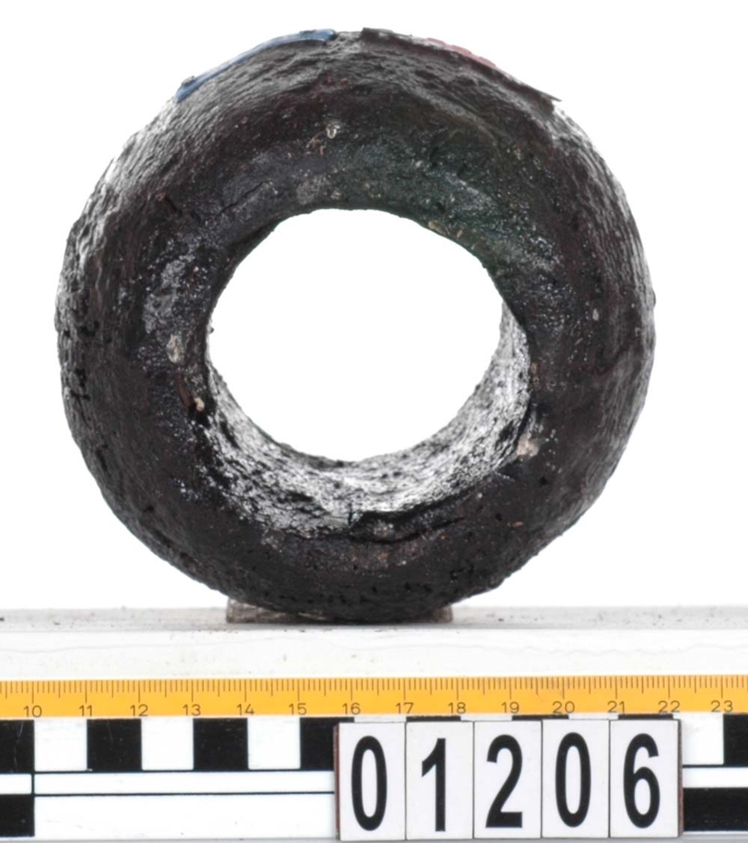 Rackklot. Runt svarvat klot med ett borrat genomgående hål. Saknar fyndbricka men har 2 st. plastmärken och 6 spikar. Eroderat, skador kring hålen.