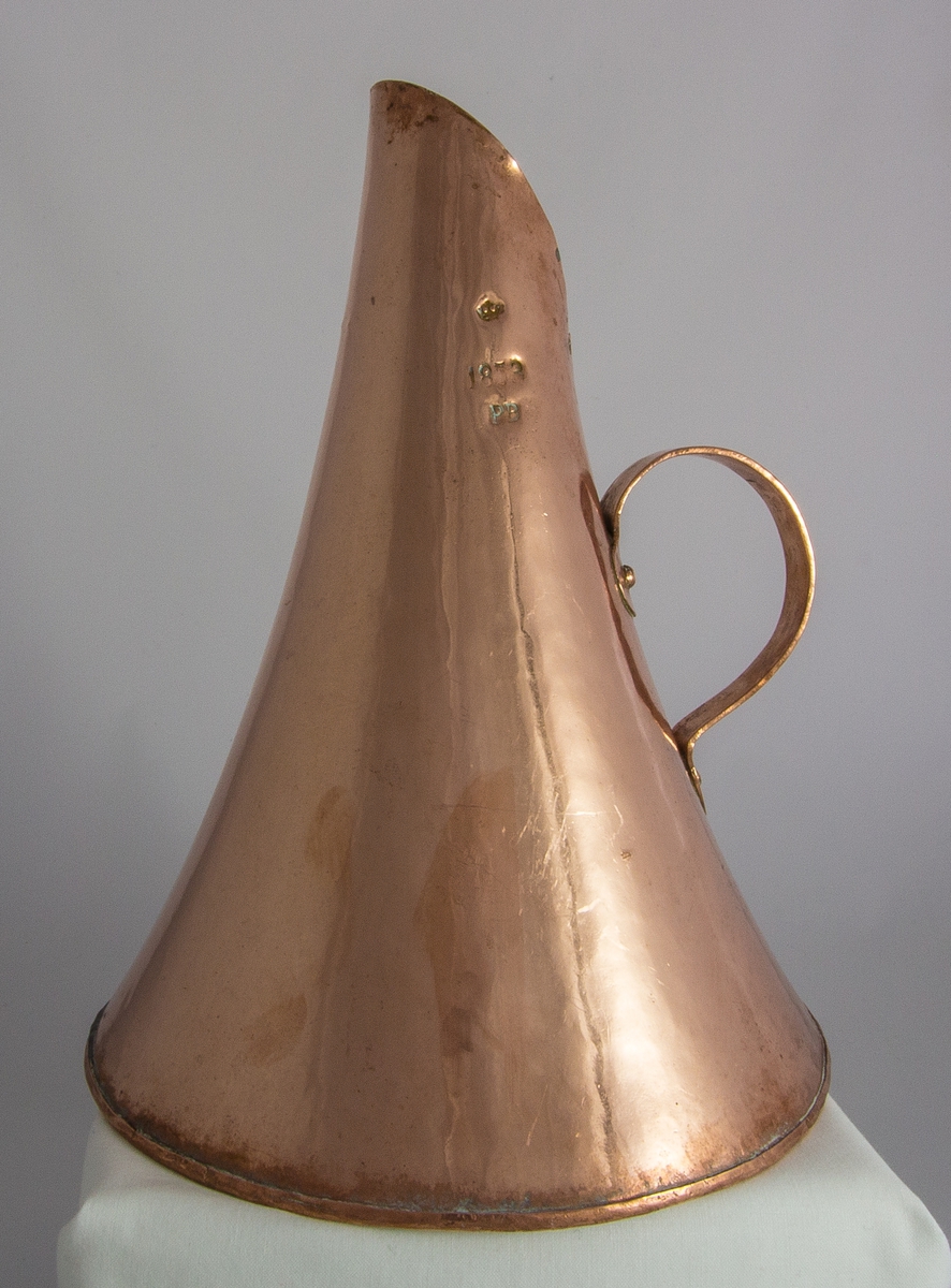 Mått, kanna, av förtent koppar med konisk form och nitat handtag. Volymmått för 2,62 l. Krönt och stämplat: 1853, PB.