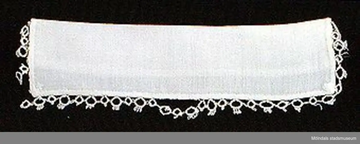 12 par vita lösmanschetter använda tillsammans med långärmade plagg. En del märkta med nr 41. 02253_1 L: 160 mm B: 55 mm._2 L: 160 mm B: 45 mm._3 L: 170 mm B: 60mm. Ribbat tyg._4 L: 190 mm B: 55 mm. Ribbat tyg._5 L: 200 mm B: 50 mm. Hålsömsprydda._6 L: 165 mm B: 80 mm. Hålsömsprydda (ej stärkta, märkta 15)._7 L: 160 mm B: 80 mm. Hålsömsprydda._8 L: 200 mm B: 50 mm. Hålsömsprydda._9 L: 180 mm B: 50 mm. Öglemönstrad spets längs kanten._10 L: 170 mm B: 55 mm. Smal spets längs kanten._11 L: 160 mm B: 45 mm. Spets längs kanten._12 L: 165 mm B: 50 mm. Ögleartad spets längs kanten.Paren förvaras i en tom chokladask (Cloetta Bristol praliner). Dessa har använts av vårdarinna Karin Hasselberg på Stretered.