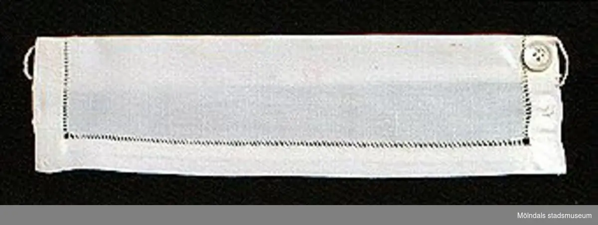 12 par vita lösmanschetter använda tillsammans med långärmade plagg. En del märkta med nr 41. 02253_1 L: 160 mm B: 55 mm._2 L: 160 mm B: 45 mm._3 L: 170 mm B: 60mm. Ribbat tyg._4 L: 190 mm B: 55 mm. Ribbat tyg._5 L: 200 mm B: 50 mm. Hålsömsprydda._6 L: 165 mm B: 80 mm. Hålsömsprydda (ej stärkta, märkta 15)._7 L: 160 mm B: 80 mm. Hålsömsprydda._8 L: 200 mm B: 50 mm. Hålsömsprydda._9 L: 180 mm B: 50 mm. Öglemönstrad spets längs kanten._10 L: 170 mm B: 55 mm. Smal spets längs kanten._11 L: 160 mm B: 45 mm. Spets längs kanten._12 L: 165 mm B: 50 mm. Ögleartad spets längs kanten.Paren förvaras i en tom chokladask (Cloetta Bristol praliner). Dessa har använts av vårdarinna Karin Hasselberg på Stretered.